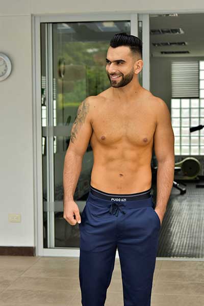 hombre a torso desnudo modelando pantalon de color azul oscuro