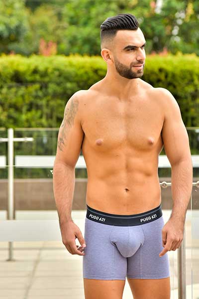 hombre a torso desnudo modelando ropa interior de color azul gris
